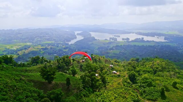 Aerial views of paragliders soaring over green landscapes and a hot air balloon floating above rolling hills and lakes in Lake Sebu, South Cotabato, Philippines.