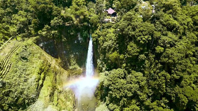 A waterfall in Lake Sebu, South Cotabato, Philippines, cascading from jungle-bordered terrain through a dense forested valley into a secluded, crystal-clear tropical pool.