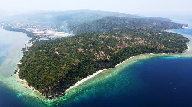 Aerial and scenic shots of lush forested tropical islands and peninsulas off Glan, Sarangani, Philippines, emerging from clear blue water against a distant mainland backdrop.