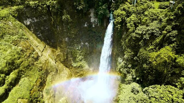 Powerful cascading waterfalls within lush tropical gorges in Lake Sebu, South Cotabato, Philippines, with vibrant green foliage and a misty, rainbow-drenched cascade.