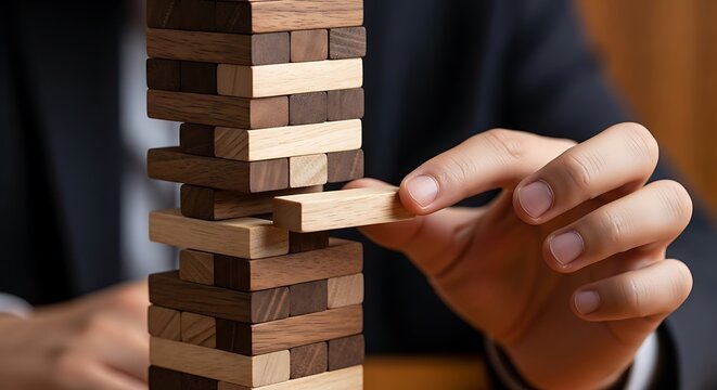 Person playing Jenga with wooden blocks game hand