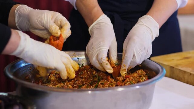 Stuffed vegetables are carefully arranged in a pot in an organized manner. The process highlights traditional cooking preparation, attention to detail, and structured layering in a kitchen environment