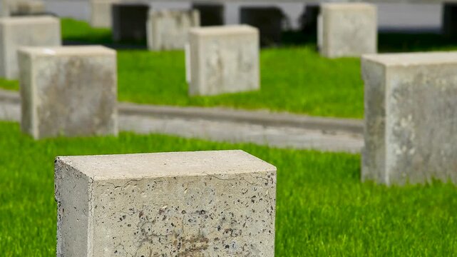 Military cemetery with rows of white tomb stones on green grass lawn
