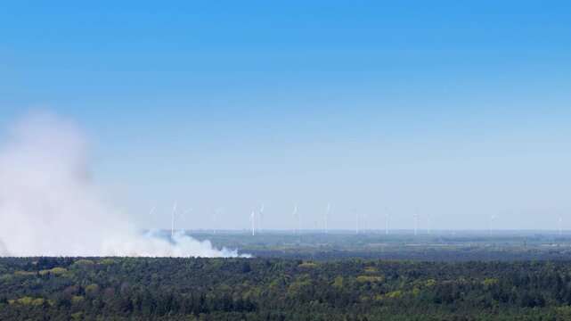 Wildfire in the Veluwe nature reserve with thick smoke rising up over the trees in Gelderland The Netherlands seen from above.