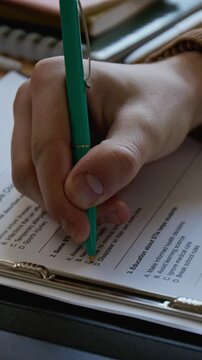 Vertical close-up of hand of unrecognizable male student completing STI awareness test at sexual education lesson, choosing correct answer from multiple choice on infection prevention and treatment