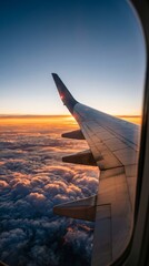 Obraz premium Wing view of airplane with scenic sunset and clouds from passenger window
