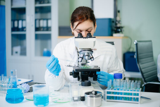 Scientists in laboratory conducting research, analyzing samples with microscope and data, healthcare innovation, medical testing