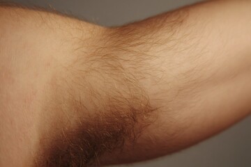 Fototapeta premium Close up of human arm and underarm with natural brown hair growing, highlighting body positivity and authenticity