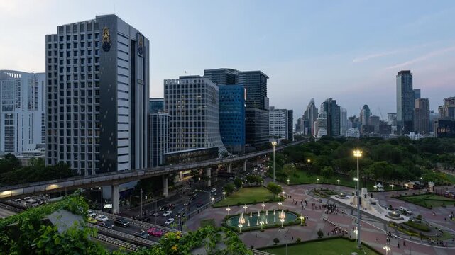Bangkok, Thailand - April 24 2026: Nightfall time lapse of the sunset over Lumphini park in downtown Bangkok by Silom with BTS train riding above the busy street in the heart of Thailand capital city