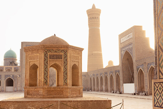 Kalyan Minaret and mosque courtyard at Poi Kalyan Square in Bukhara with ornate brickwork and tile decoration. Ideal for travel, heritage, and tourism publications.
