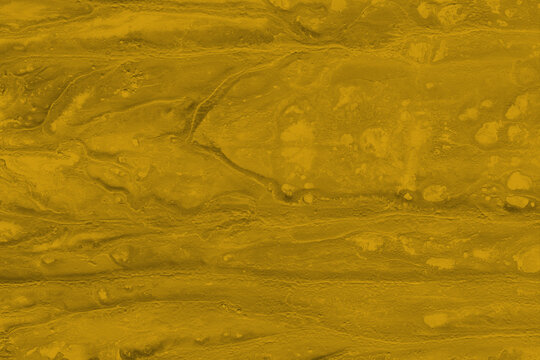 Textura abstracta de color ocre dorado con relieve rugoso, grietas y detalles org&aacute;nicos.
