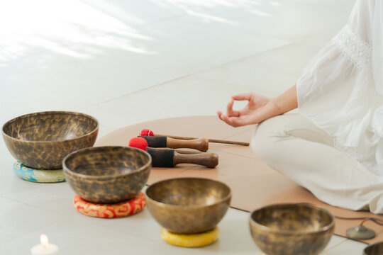 Meditation sound healing with calm hand and singing bowl set in bright studio, peaceful wellness practice and soft relaxation