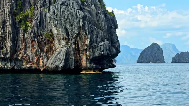 Sailing slowly past the limestone karst cliffs in the water near Palawan Island in the Philippines.