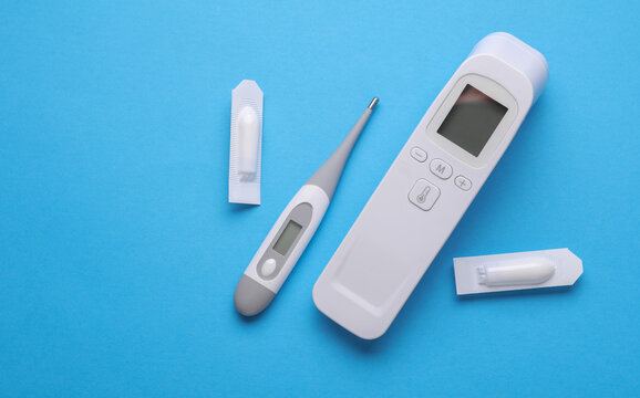 Rectal suppositories and thermometer on a blue background