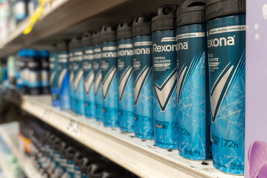 Villa de Alvarez, Colima. April 14, 2026: Row of Blue Aerosol Deodorant Spray Cans Labeled Rexona on Shelf
