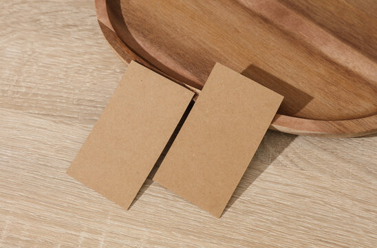 Natural wooden tray with blank craft business cards on table. Corporate Identification. Business concept