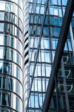 Vertical corporate building with steel and glass facade windows reflections and modern architecture lines creating office tower background in daylight