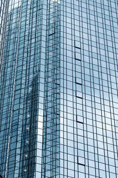 Vertical glass tower skyscraper with modern architecture facade windows grid and reflections on highrise building creating corporate urban background