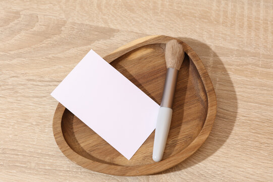 Makeup brush with blank card in a wooden tray