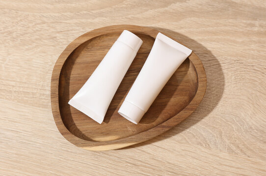 White blank crem tubes in a wooden tray. Beauty concept
