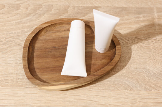 White blank crem tubes in a wooden tray. Beauty concept