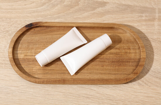 White blank crem tubes in a wooden tray. Beauty concept