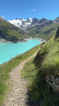 Lac de Moiry reservoir with turquoise water on the Haute Route hiking trail from Chamonix to Zermatt, Valais, Switzerland

