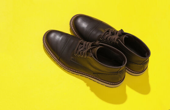 Classic man's Leather boots on a yellow background