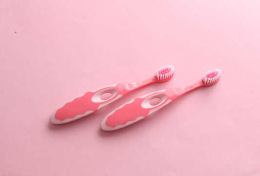 Children's toothbrushes on pink background. Top view