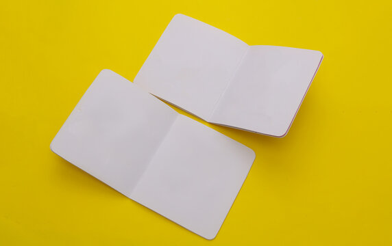 White open blank books or booklets mockups on yellow background
