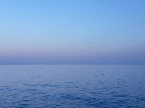 Tranquil ocean blue water and sky at evening.