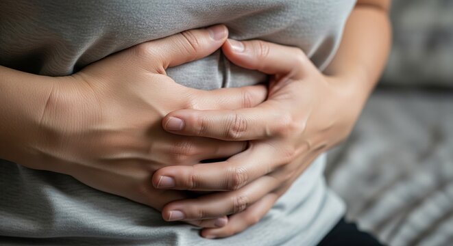 Close Up Of Woman Pressing Her Abdomen Showing Signs Of Severe Stomach Pain And Bloating