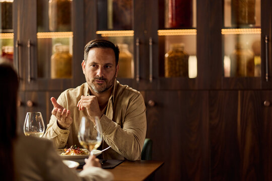 Business Dinner Conversation Between Man And Woman In Upscale Restaurant Discussing Ideas