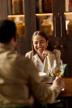 Smiling Woman Enjoying Business Lunch Conversation With Colleague In Cozy Restaurant