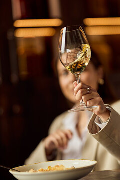 Businesswoman Toasting With White Wine During Elegant Restaurant Dinner Meeting For Celebration And Networking