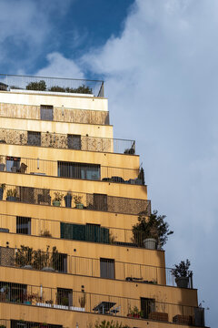 Stepped building architecture with modern urban apartment terrace where plants rise toward the sky and facade design forms a bold city profile