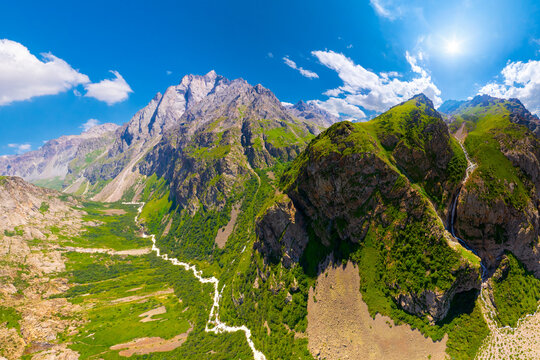 Majestic mountain range with lush green valleys and winding river