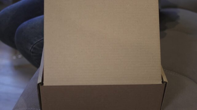 Cardboard box. Candle. Candle in a glass. Close the cardboard box. Gift wrapping. Slow motion video. High quality 4k footage