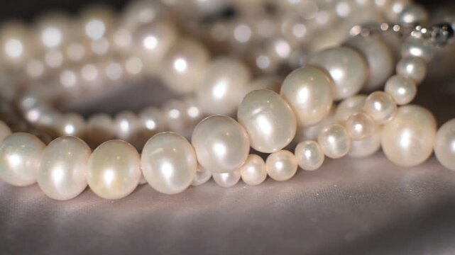 Minimal pearl texture on gray background, elegant jewelry backdrop.
Minimalistic arrangement of pearl strands on a clean gray background.