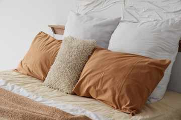 Obraz premium Cozy bed with soft pillows in stylish bedroom, closeup