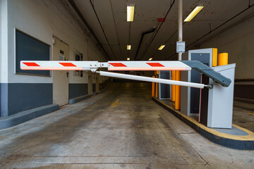 Automatic barrier gate arm closed at an underground parking garage entrance in Budapest, Hungary, providing security and access control to a private vehicle parking lot. © soleg