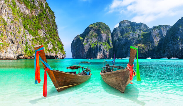 Two Longtail Boats in Maya Bay, Phi Phi islands in Thailand. Traditional Thai longtail boats anchored in shallow turquoise water of Maya Bay with dramatic cliffs, symbol of Southeast Asian travel.