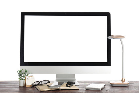 Modern desktop workspace with blank computer monitor, smartphone, glasses, lamp, keyboard, notebook, calendar and plant on wooden desk isolated on white background