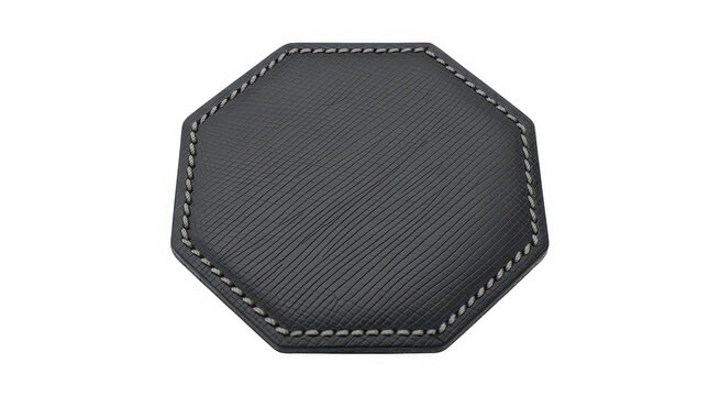 A black textured leather octagonal coaster with grey stitching isolated on a white background