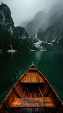 wooden boat on the lake in mountains, foggy weather, beautiful scener
