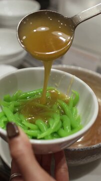 Pouring Sweet Coconut Milk Over Green Rice Flour Noodles Dessert