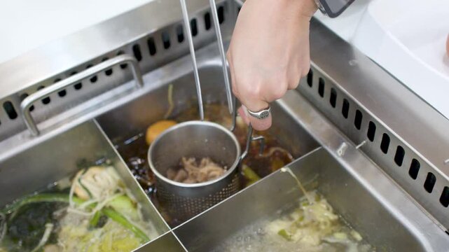Cooking Sliced Pork in a Hot Pot Metal Strainer Basket