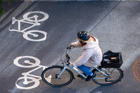 Topdown view in Stockholm Sweden of a cyclist on a bicycle in a bike lane with markings showing urban safety and commute mobility daily