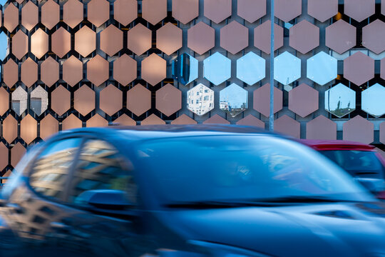 Car traffic in Stockholm Sweden becomes motion blur against a modern urban facade pattern creating a clean graphic sense of speed today