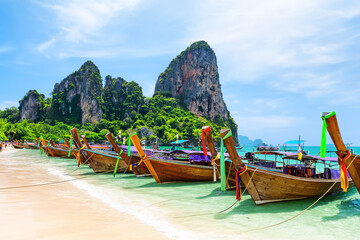 Fototapeta premium Longtail Boats on amazing Railay Beach in Krabi province. Ao Nang, Thailand. Scenic Railay Beach with traditional boats, turquoise water and limestone cliffs in Krabi, Thailand